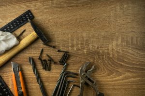 Screws and drill bits on a wooden background