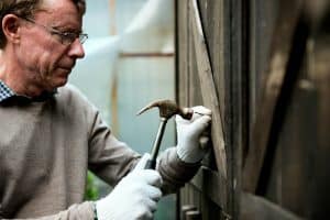 Man hammering nail on wood