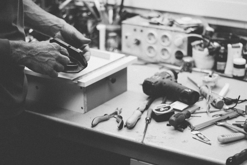 Grayscale photo of a person holding a handtool