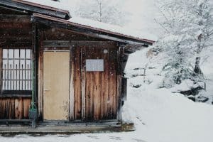 Brown wooden house covered in snow